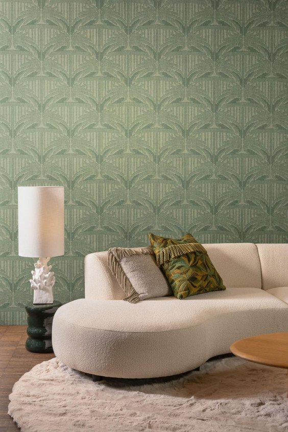 Ambiance de salon moderne avec papier peint vert sauge motif palme Indienne Agra 18310 derrière un canapé blanc arrondi.