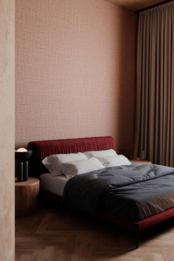 Papier peint texturé effet tissé rose cuivre Merino Lana dans une chambre à coucher moderne avec lit bordeaux et chevets en bois.
